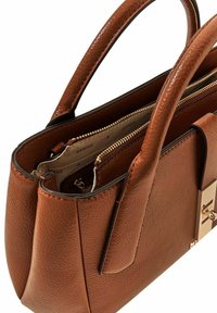 Sac à main en cuir marron avec deux poignées, compartiments zippés à l'intérieur, surface texturée et détails en métal doré sur le côté.