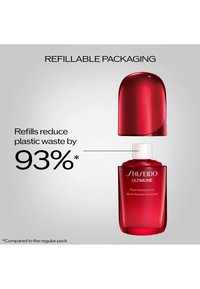 Flacon rouge rechargeable de sérum Shiseido Ultimune sans son bouchon, mettant en avant une réduction de 93 % des déchets plastiques par rapport à l'emballage classique.