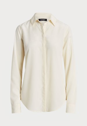 Chemise à manches longues crème clair avec un col pointu, un devant à boutons et une texture lisse ; présente un ourlet arrondi et une coupe ajustée.