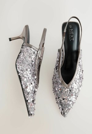 Silver sequined slingback heels with a pointed toe and a slim stiletto heel. The upper features a textured surface with reflective embellishments.