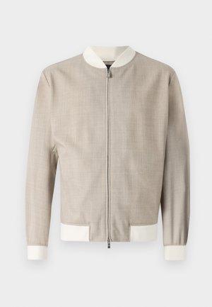 Heledbeez bomber-jakk, millel on tekstureeritud kangas, valge krae ja mansetid, ning esine lukustus. Lihtne, voolujooneline disain.