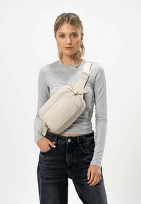 Borsa a tracolla beige con finitura texturizzata, forma rettangolare, tasca frontale con cerniera, tracolla regolabile e dettagli metallici.