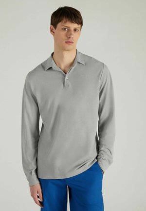 Grijs poloshirt met lange mouwen en een knoopsluiting, gemaakt van een gladde stof, gecombineerd met blauwe broek. Kenmerkt zich door een ontspannen pasvorm.