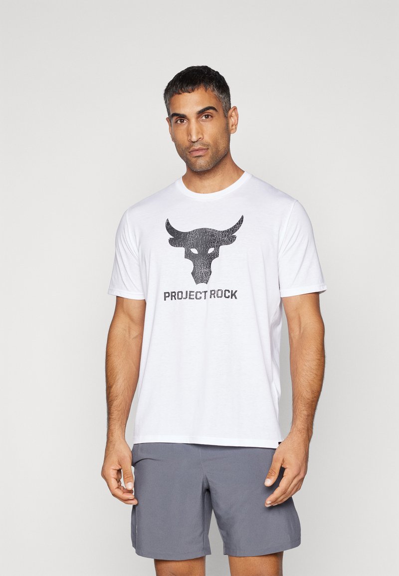 T-shirt en coton blanc avec un graphique de taureau noir et le texte "PROJECT ROCK" en dessous. Manches courtes et col rond.
