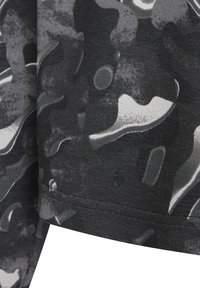 Tela de camuflaje en negro y gris, con una textura suave, presentada en formas abstractas y sutiles variaciones tonales. Dobladillo visible en la parte inferior.