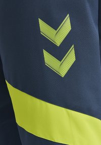 Two patterned lime green chevrons above a wide diagonal lime green stripe on dark blue fabric.