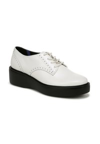 Scarpa bianca in pelle con lacci, caratterizzata da cuciture decorative e suola piatta nera. Presenta una punta tondeggiante e una texture liscia.