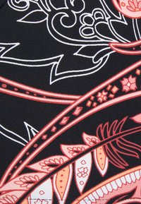 Tecido preto com intrincados padrões florais e geométricos em vermelho, rosa e branco, formando formas curvas e folhosas.