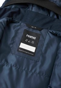 Marineblauwe geïsoleerde jas met een interieur van een gladde satijnen textuur. Inclusief maatlabel, verzorgingssymbolen en het merkembleem op een zwart label.