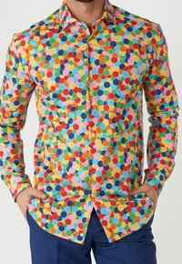 Camisa de botones colorida con un patrón de lunares en rojo, amarillo, azul, verde y rosa sobre un fondo blanco. Tejido de algodón.