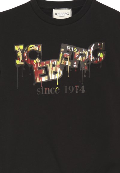 T-shirt nera in cotone con logo "ICEBERG" in stile graffiti multicolore e a goccia, accompagnato dalla scritta "dal 1974" in un font stilizzato.