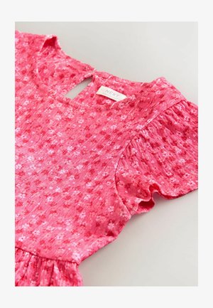 Rožinė gėlėta suknelė su trumpomis raukšlėtomis rankovėmis, apvali iškirpte ir atvira nugara su raktelio formos anga. Pagaminta iš lengvos, tekstūruotos medžiagos.