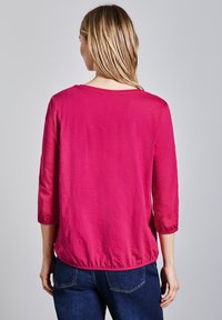 Fuchsie, lehký top s tříčtvrtečními rukávy, elastickým lemem a uvolněným střihem. Hladká textura s jednoduchým, čistým designem.