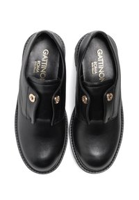 Mustat nahkakengät, joissa on sileä pinta, pyöreä kärki ja kultaiseen nappiin varustettu nappi kummallakin puolella. Sisäpuoli on brändätty kullalla.