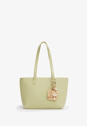 Jasnozielona torba typu tote z długimi uchwytami i małym plecionym charms z muszlami i koralikami, przymocowany złotymi kółkami.
