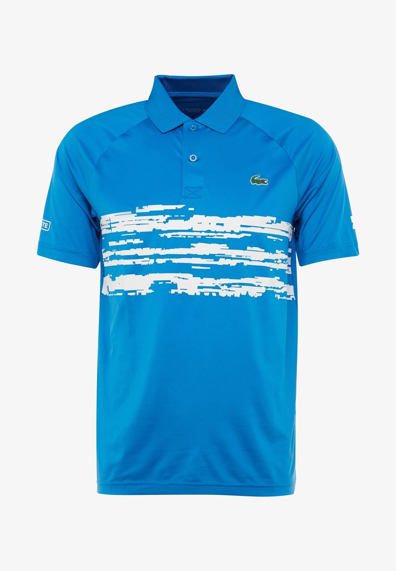 Blå pikétröja gjord av slät tyg, med en vit penseldragsdesign över bröstet och en liten grön logotyp på vänster sida.