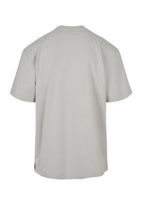 T-shirt uni gris clair à manches courtes, vu de dos, avec un col rond et une coupe décontractée.
