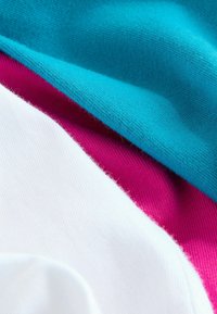 Lagdelstof med farverne turkis, magenta og hvid. Blød strikket tekstur med synlige fibre og glatte overflader.