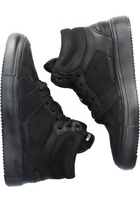 Ett par svarta hög-top sneakers med tjocka sulor, snörning framtill och vadderade vristkollare, visade sida vid sida på vit bakgrund.