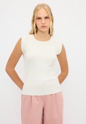 Haut blanc à manches courtes nervuré avec une silhouette ajustée et un décolleté rond, associé à un pantalon large rose clair. Texture lisse.
