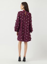 Lilla satindress med 3D blomsterapplikasjoner og sølvdekorasjoner, lange ermer, midtlang lengde, og åpen rygg med nøkkelhull.