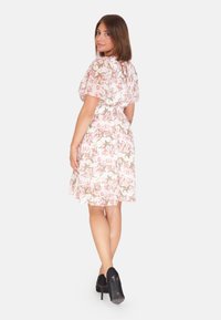 Blumenkleid in Hellrosa mit kurzen, schwingenden Ärmeln, tailliertem Bund und knielangem Saum; verfügt über einen gebundenen Rückenverschluss und ein zartes Blumenmuster.