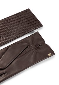 Guanti in pelle marrone con una texture lavorata a maglia sul dorso, caratterizzati da un logo a contrasto e un design aderente con punte delle dita scoperte.