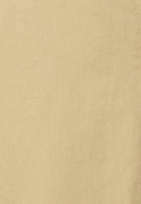 Tissu beige clair avec une texture côtelée diagonale, présentant une finition lisse et un toucher doux, adapté à diverses applications comme le revêtement ou la mode.