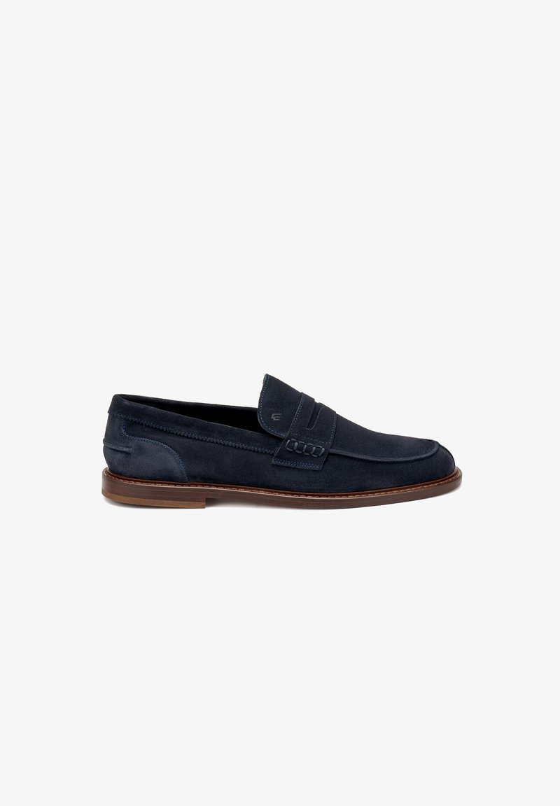 Mocassini in suede blu navy con design a mocassino, dettagli cuciti e suola in gomma marrone. Stile slip-on con una fascia frontale.