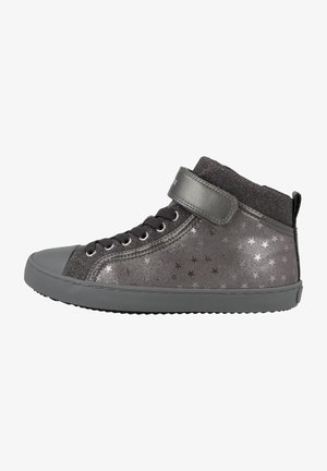 Zapatilla alta en gris oscuro con patrones de estrellas metálicas. Presenta una punta de goma y una correa de velcro para un ajuste seguro. Parte superior texturizada.