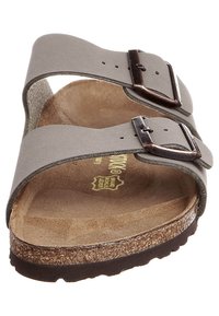 Grå ruskinds sandaler med to justerbare metalspænder, korksål og struktureret gummisål. Minimalistisk design med åben tå og hæl.