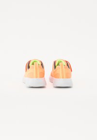 Neon orange athletic shoes with a textured mesh upper, white rubber outsole, and contrasting green accents at the tongue and collar.