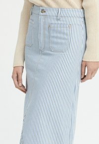 Gestreifte Jeansrock in Hellblau und Weiß, mit einem Frontknopfverschluss, zwei Seitentaschen und einem geraden Schnitt.