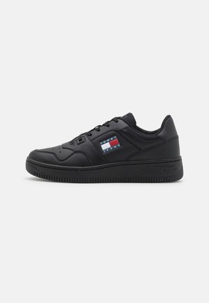 Czarny niski sneaker z sznurowaniem z przodu, gładki skórzany design i naszywką z logo Tommy Jeans po boku.