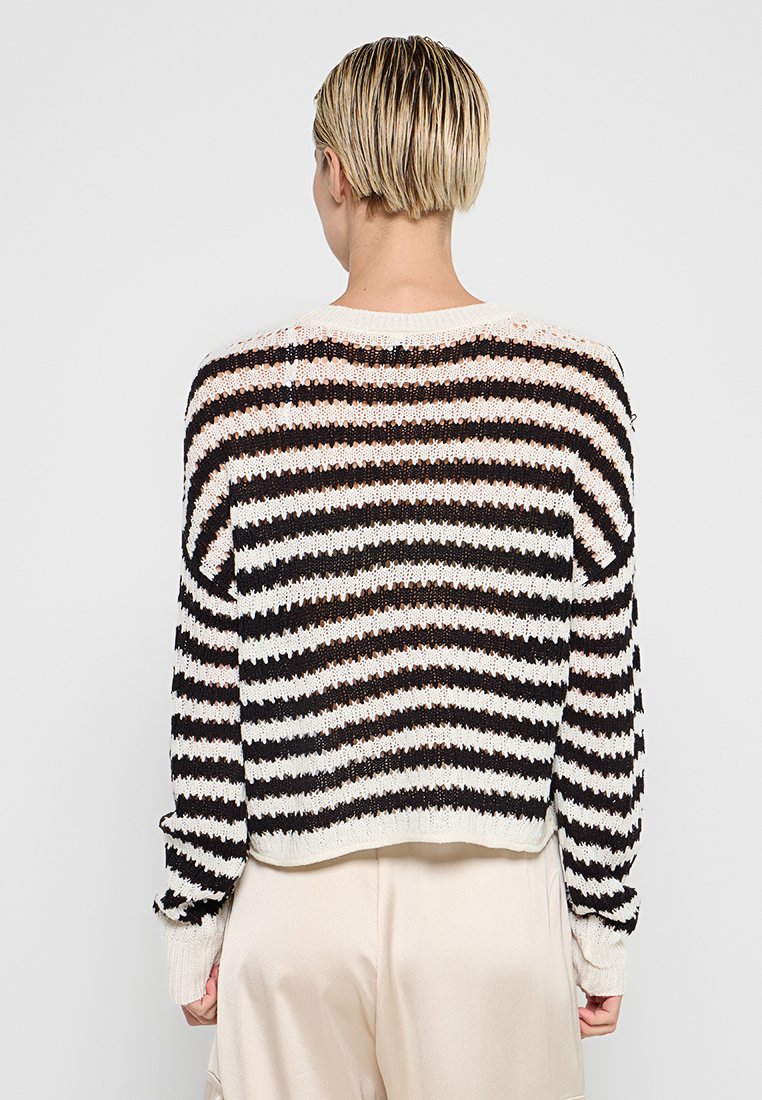 Schwarz-weißer gestreifter Strickpullover mit lockerer Passform, gerippten Bündchen und rundem Halsausschnitt. Offene Strickstruktur sichtbar auf der Rückseite.