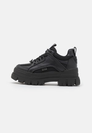 Czarne masywne sneakersy wykonane z mieszanki gładkich i teksturowanych materiałów. Charakteryzują się grubą podeszwą, okrągłym noskiem i sznurowanym przodem.