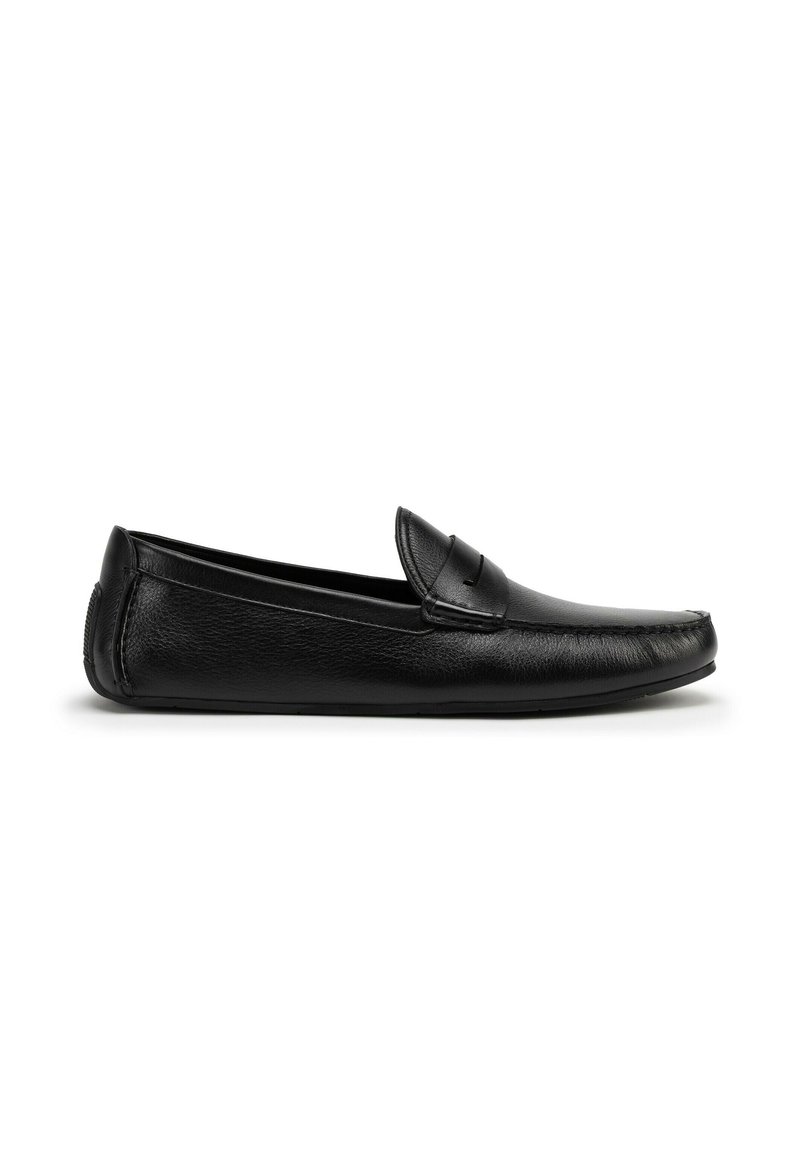 Mocasines de cuero negro con puntera redondeada, superficie texturizada y un detalle de costura elevada a lo largo de la parte superior. Suela de goma flexible para mayor comodidad.