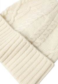 Cappello di maglia a treccia in color crema, realizzato in lana, con una parte superiore testurizzata e un bordo a costine per garantire calore e una vestibilità aderente.