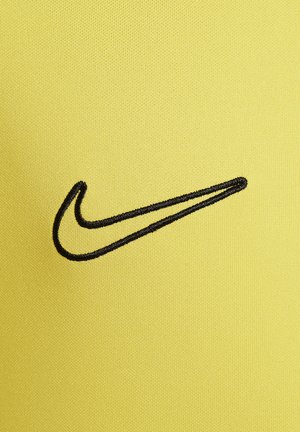 Gelbes Material mit einer glatten Textur zeigt prominent das gestickte schwarze Nike-Swoosh-Logo. Das Design ist einfach und modern.