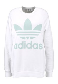 Valkoinen collegepaita, joka on valmistettu puuvillasekoitteesta ja jossa on suuri mintunvihreä Adidas-logo sekä kolmiraidallinen kuosi rinnassa. Klassinen malli.