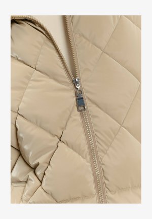 Beżowa pikowana kurtka puchowa z wyraźnym zamkiem błyskawicznym, błyszczącą fakturą i wzorem w romby. Zamek posiada metalowy uchwyt.
