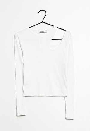 Witte lange mouw ribgebreide top met asymmetrische halslijn en uitsnijding op de rechter schouder, hangend aan een zwarte hanger tegen een witte achtergrond.