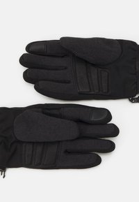 Gants noirs en tissu texturé avec des accents en cuir lisse. Comprend des sections rembourrées et des doigts compatibles avec les écrans tactiles.