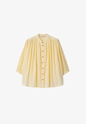 Blassgelbe, weit geschnittene Bluse mit langen Ärmeln, gerafftem Stoff an Schultern und Bündchen sowie einer vorderen Knopfleiste und rundem Ausschnitt.