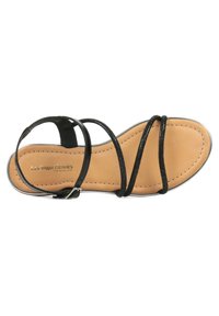 Sandal nera con strappi sottili e più cinturini, dotata di una soletta beige. Presenta dettagli cuciti e una fibbia in tonalità argento.