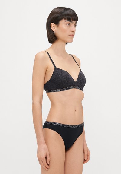 Black bralette with glittery fabric, V-neck design, adjustable straps, and branded elastic band; matching black bikini with logo waistband.