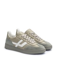 Beige und graue Wildledersneaker mit weißen Seitenstreifen, beigen Schnürsenkeln und grauen Gummisohlen, aus seitlicher Perspektive auf weißem Hintergrund gezeigt.