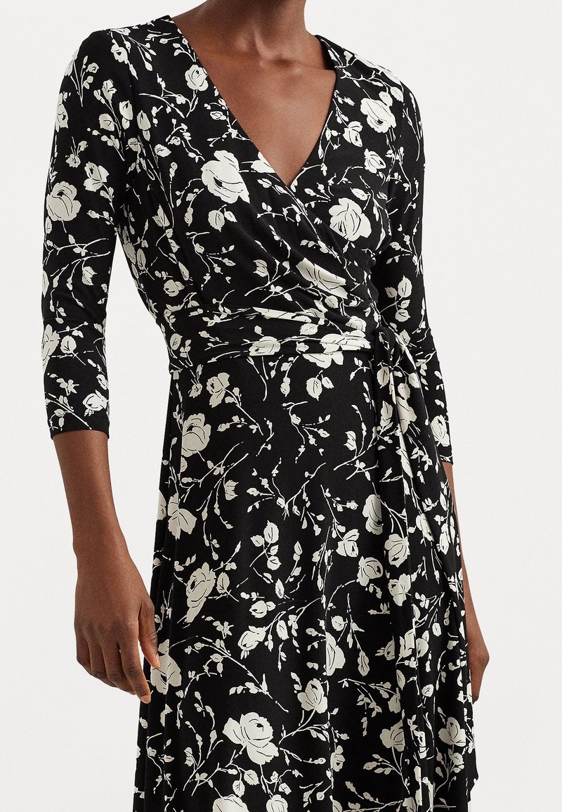 Czarna sukienka o kroju kopertowym z rękawami do łokcia, z białym kwiatowym wzorem, miękką fakturą i zawiązywaniem w talii.