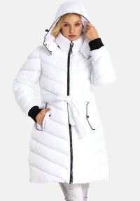 Weißer gepolsterter Wintermantel mit Kapuze, schwarzen Akzenten, einem Gürtel in der Taille, Reißverschluss und diagonalem Steppmuster.