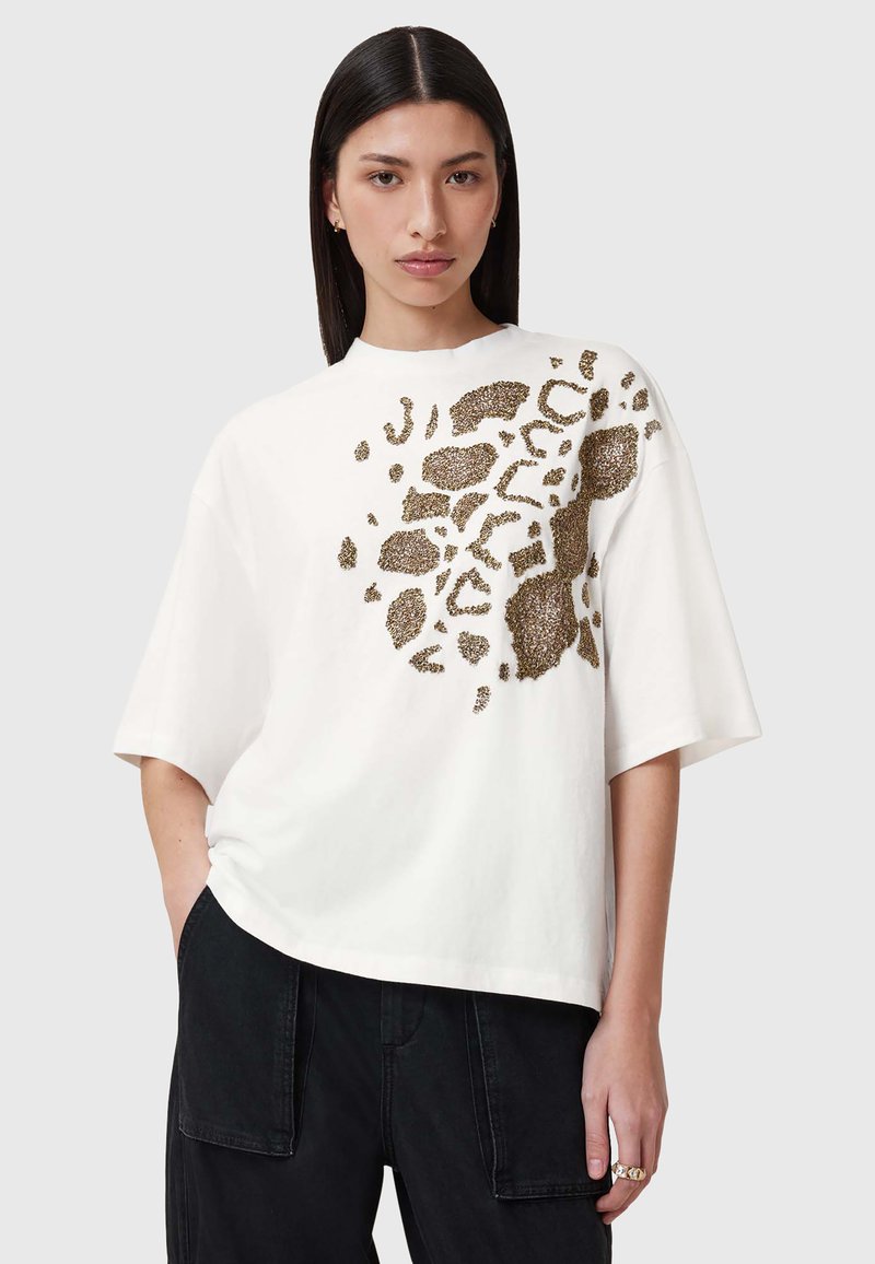 Vit kortärmad t-shirt med guld leopardtryck på framsidan. Tillverkad av bomull med en avslappnad passform och rund halsringning.